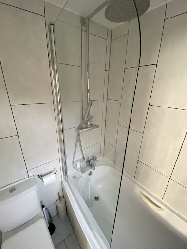 Bathroom shower wall with grey stone-effect tiles, shown in a David Jenkins Google review about bathroom tiling.